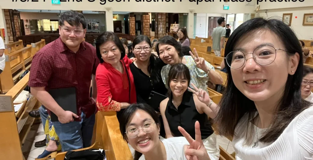 Singers from several parishes smiling together at a choir practice