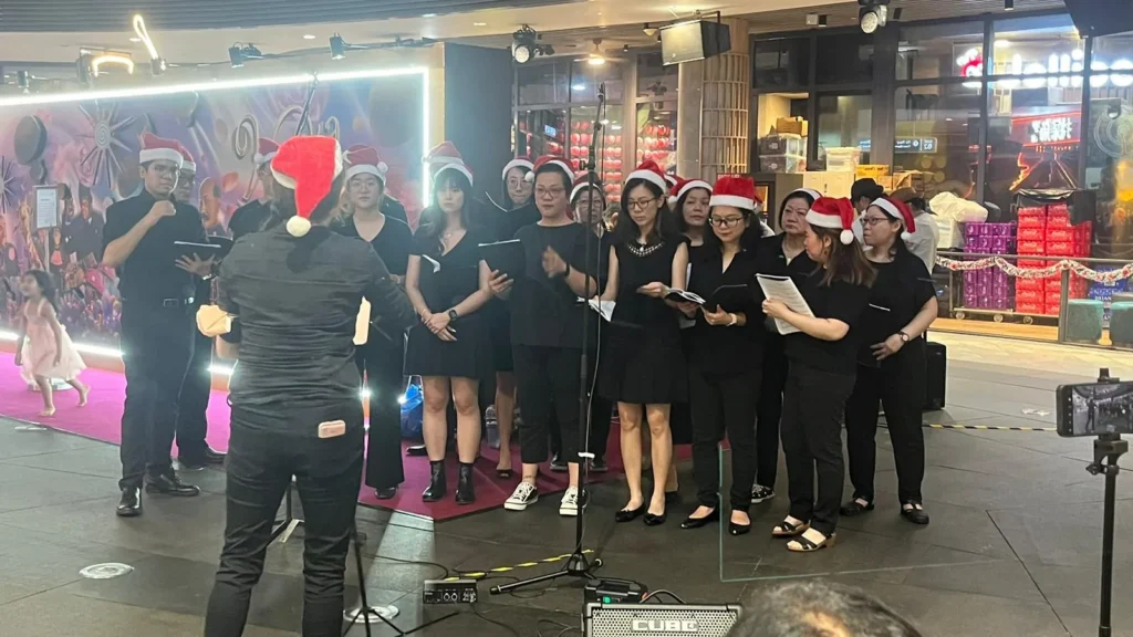 A parish choir in Santa hats carolling at a shopping mall