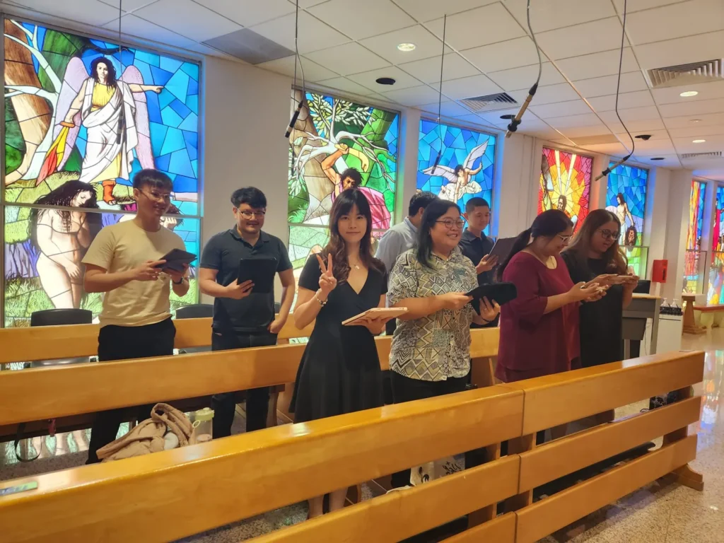 A small SATB ensemble singing from the pews at a wedding Mass, beneath stained-glass windows